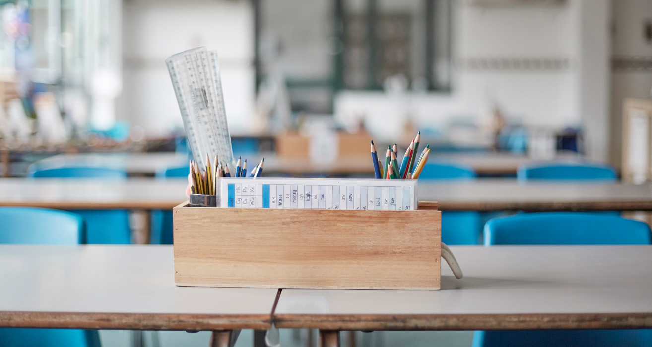 A box of school supplies in a classroom. 